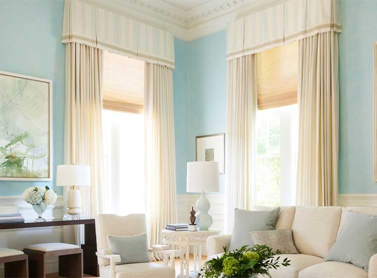Living room with two windows covered by long drapes and valances